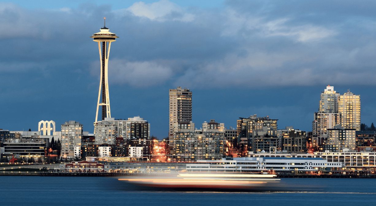 A boat is traveling on the water near some buildings.