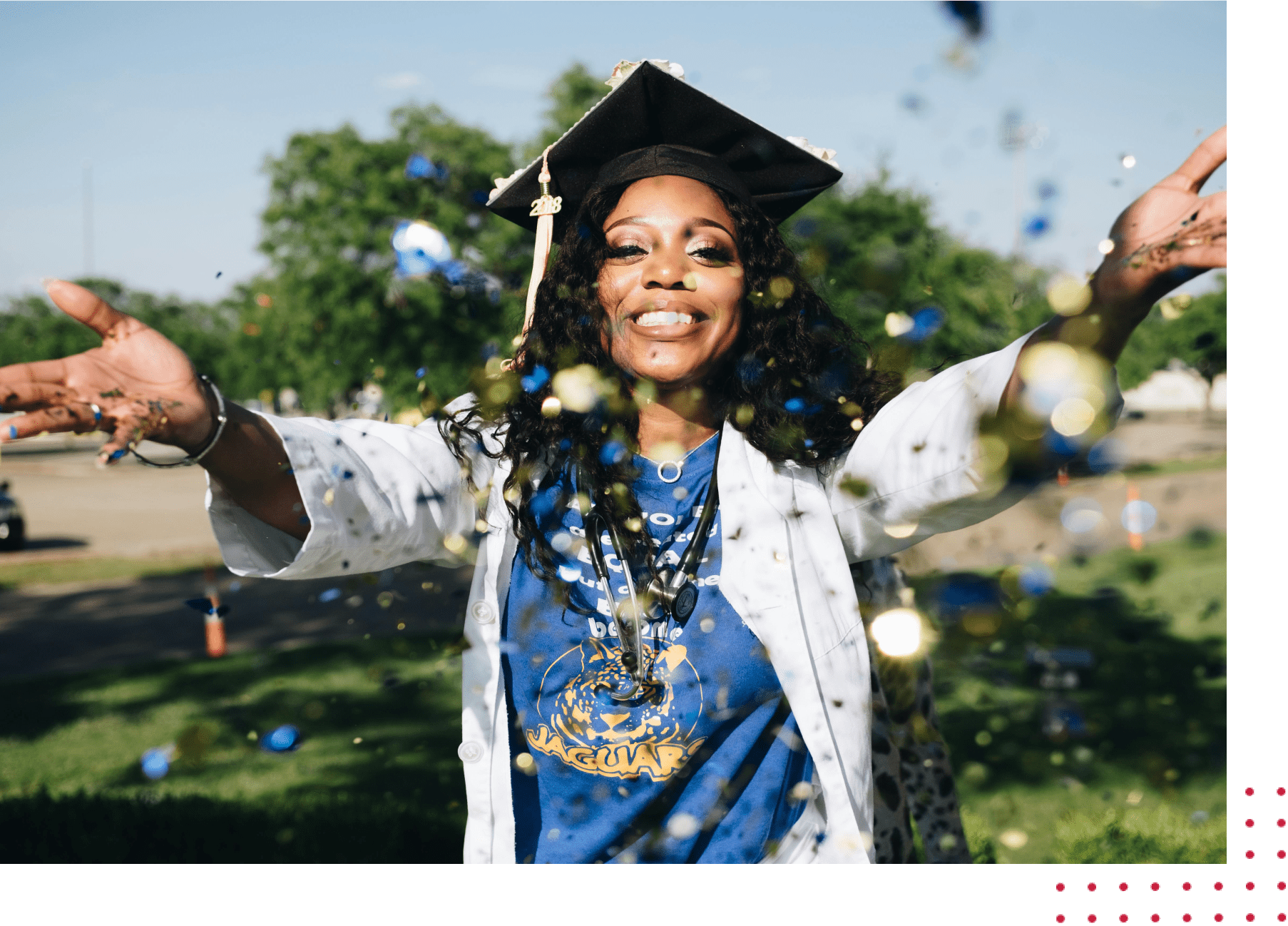 Group-8 A woman in graduation cap and gown throwing confetti.