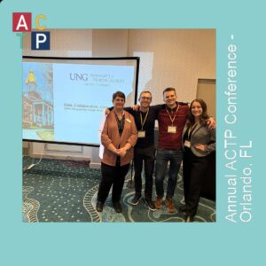 A group of people standing in front of a projector screen.