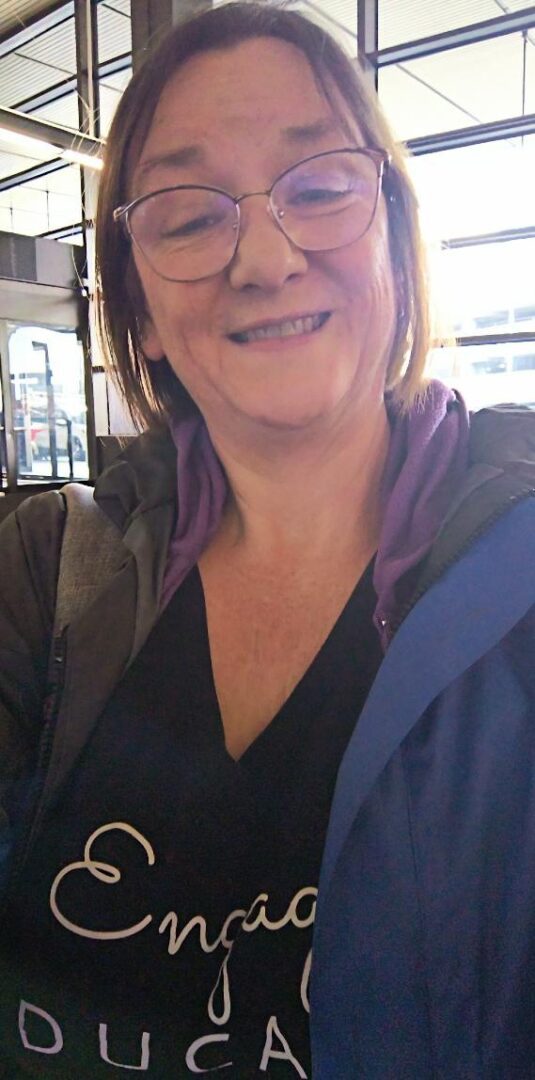Smiling woman wearing glasses and a jacket.