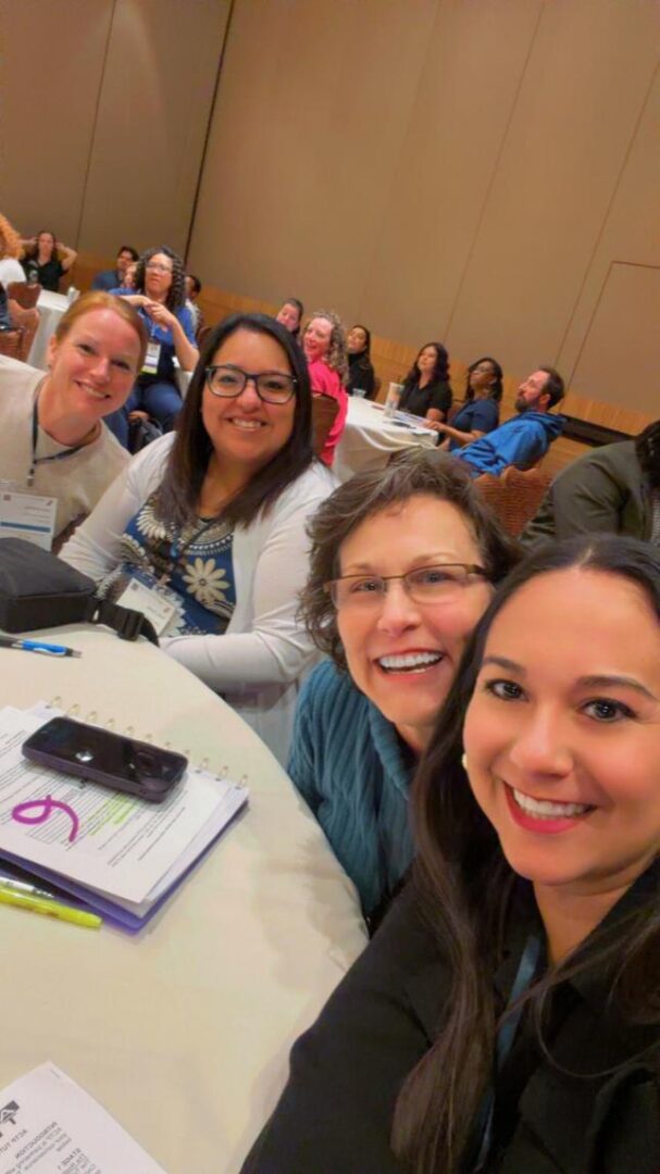 Group of people smiling at conference table.