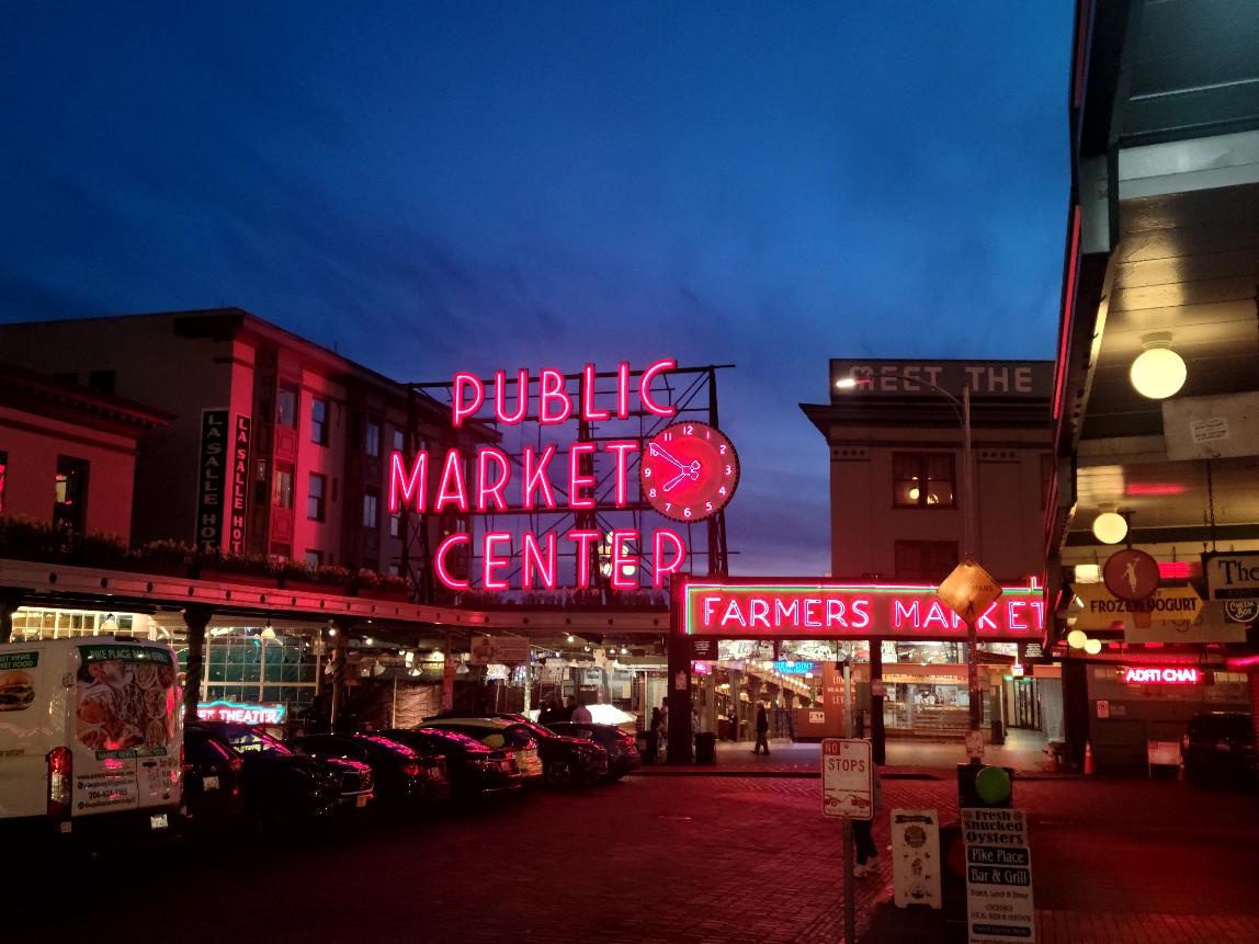 Neon-lit public market at dusk.