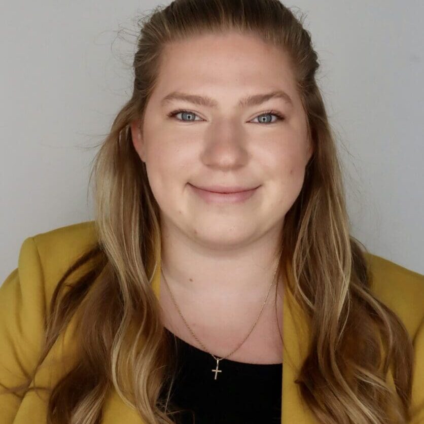 Smiling person in a yellow blazer.